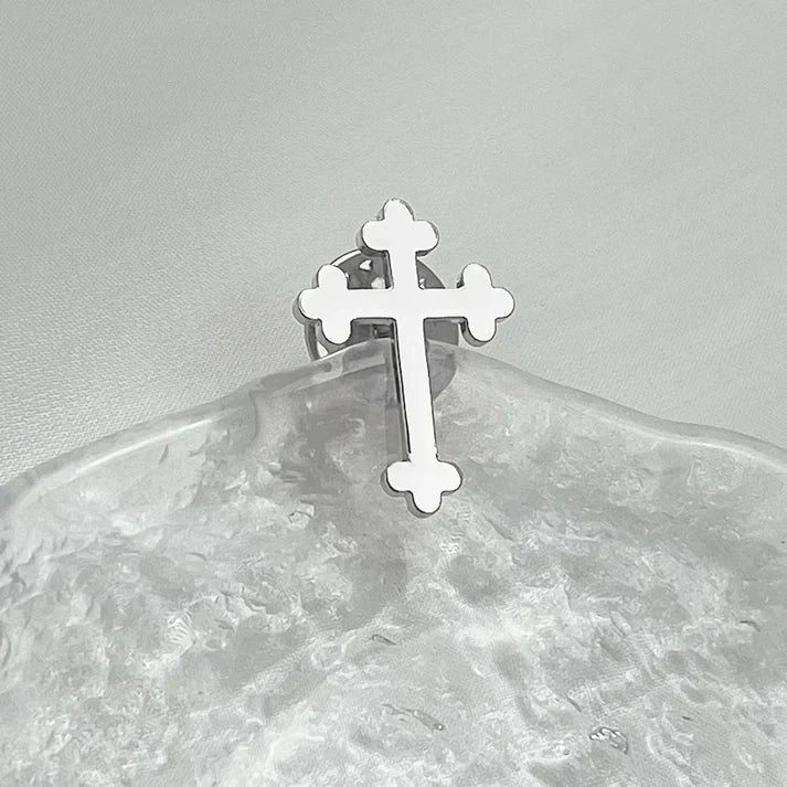 Cross lapel pin worn on a suit jacket