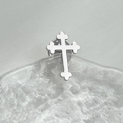 Cross lapel pin worn on a suit jacket